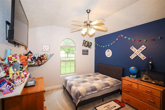bedroom with light colored carpet, vaulted ceiling, baseboards, and a ceiling fan