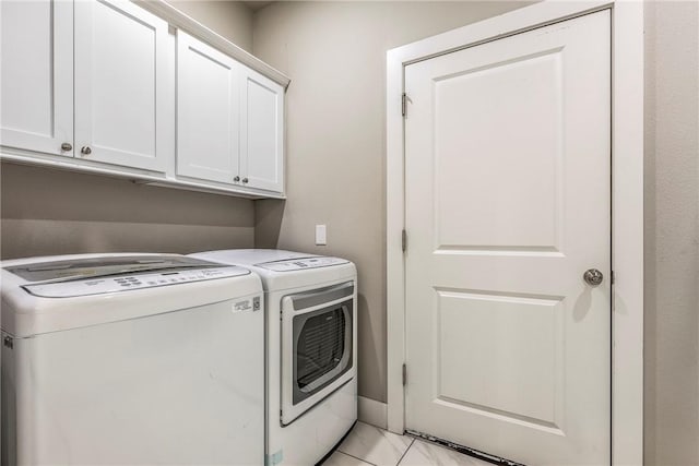 clothes washing area with washer and dryer and cabinet space