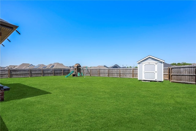 view of yard with a playground, a storage shed, and an outdoor structure