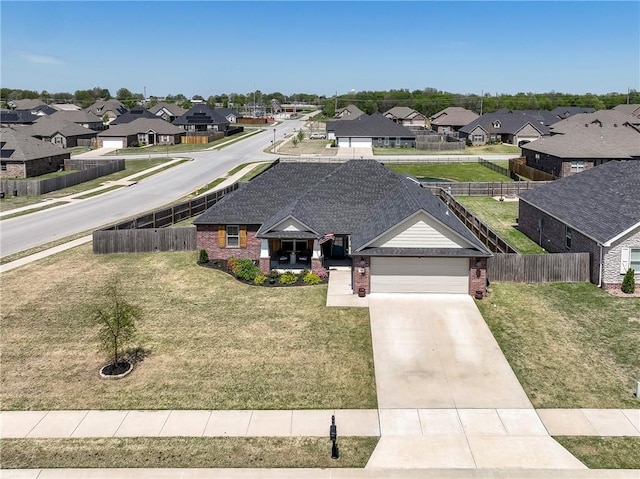view of front facade with a residential view, a garage, brick siding, and concrete driveway