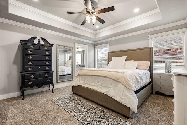 bedroom featuring a tray ceiling, carpet, ceiling fan, ornamental molding, and baseboards
