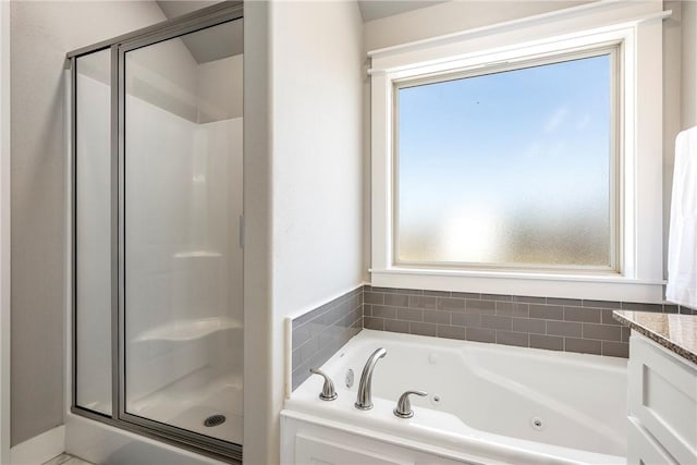 full bath with a stall shower, a whirlpool tub, and vanity