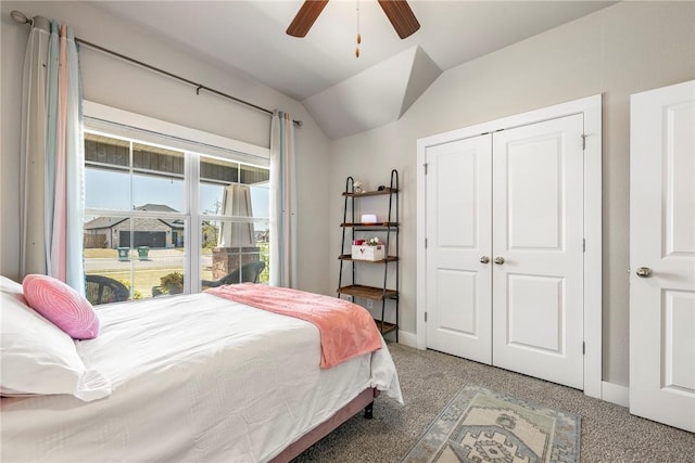 bedroom featuring light colored carpet, lofted ceiling, baseboards, a closet, and a ceiling fan