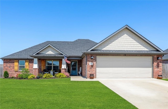 craftsman inspired home featuring driveway, a front yard, and brick siding