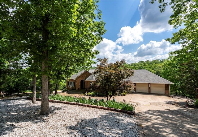 30 Brittany Ln, Bella Vista, AR 72714 - obstructed view of property with driveway, an attached garage, and brick siding