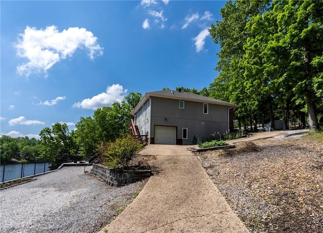 30 Brittany Ln, Bella Vista, AR 72714 - view of home's exterior with driveway, an attached garage, and stairs