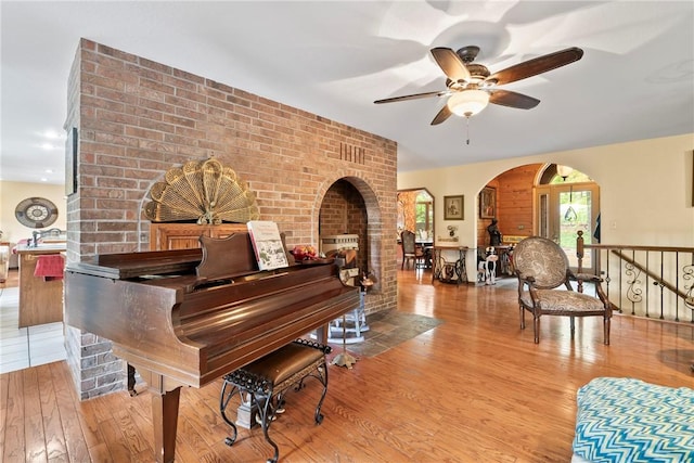 30 Brittany Ln, Bella Vista, AR 72714 - living area with wood finished floors, ceiling fan, a multi sided fireplace, and arched walkways