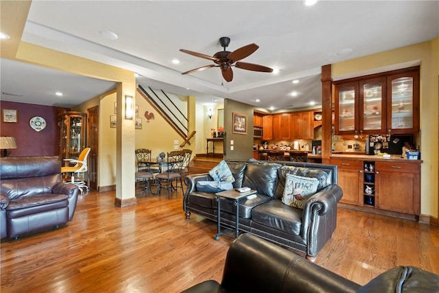 30 Brittany Ln, Bella Vista, AR 72714 - living room featuring light wood-type flooring, ceiling fan, stairs, recessed lighting, and a raised ceiling