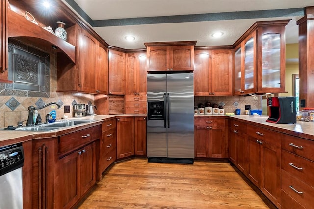 30 Brittany Ln, Bella Vista, AR 72714 - kitchen with appliances with stainless steel finishes, a sink, tasteful backsplash, light wood-style flooring, and glass insert cabinets
