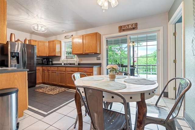 22058 Dogwood Cir, Springdale, AR 72764 - kitchen with stainless steel refrigerator with ice dispenser, dark countertops, healthy amount of natural light, and light tile patterned flooring
