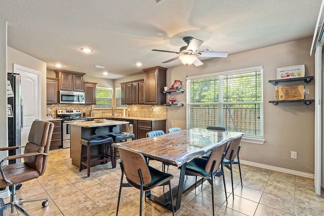 dining area featuring ceiling fan, a textured ceiling, baseboards, recessed lighting, and light tile patterned flooring
