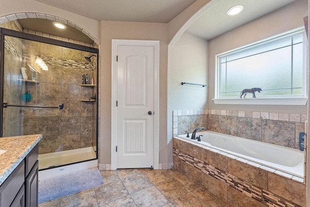 full bathroom with a garden tub, a stall shower, vanity, and baseboards