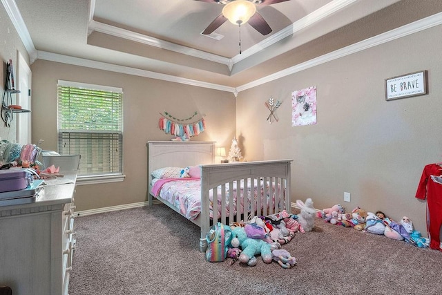 carpeted bedroom with a raised ceiling, ornamental molding, ceiling fan, and baseboards