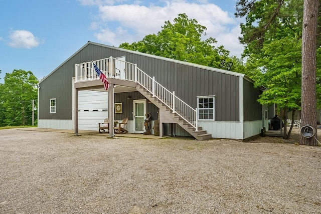 103 County Road 1522, Eureka Springs, AR 72632 - view of front of home with stairs, a wooden deck, gravel driveway, and a detached garage