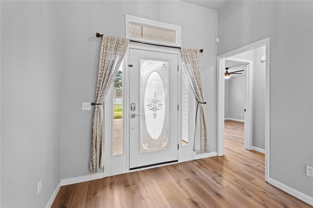 foyer featuring wood finished floors, baseboards, and a ceiling fan