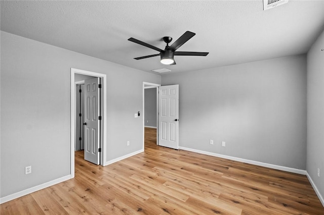 unfurnished bedroom with baseboards, light wood-style floors, ceiling fan, and a textured ceiling