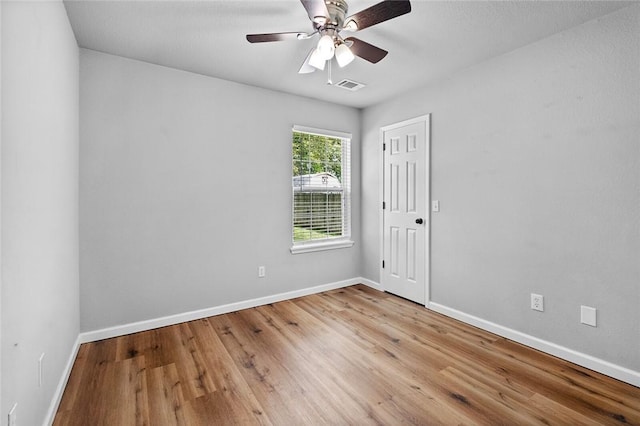 empty room with wood finished floors, baseboards, and ceiling fan