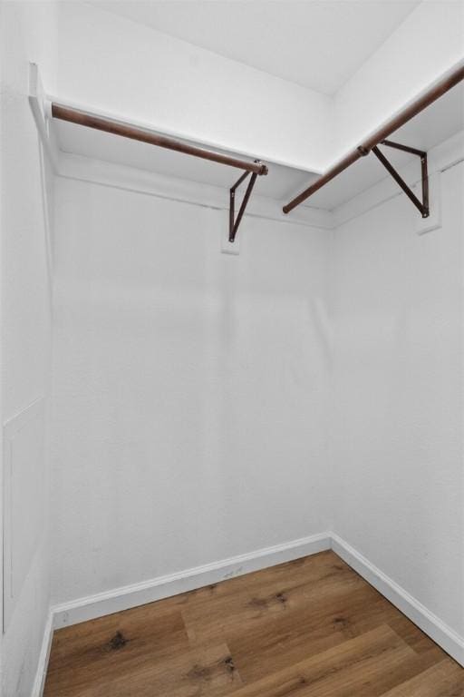 walk in closet with wood finished floors