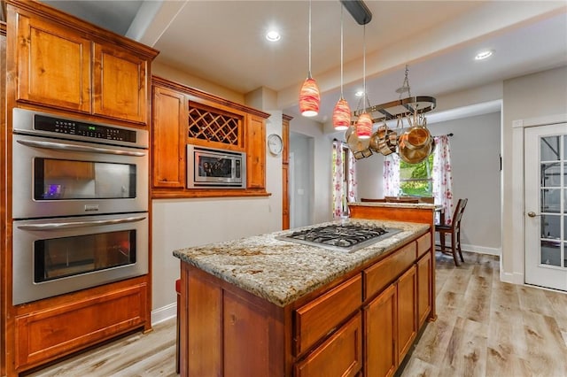 9696 Fuller Rd, Rogers, AR 72756 - kitchen featuring appliances with stainless steel finishes, light wood-type flooring, light stone counters, a center island, and recessed lighting