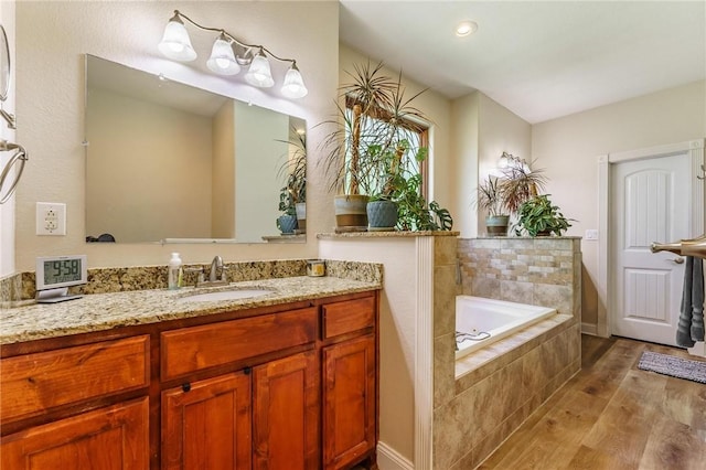9696 Fuller Rd, Rogers, AR 72756 - bathroom with wood finished floors, a garden tub, and vanity