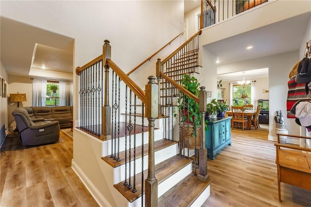9696 Fuller Rd, Rogers, AR 72756 - stairway with wood finished floors, a chandelier, baseboards, a towering ceiling, and recessed lighting