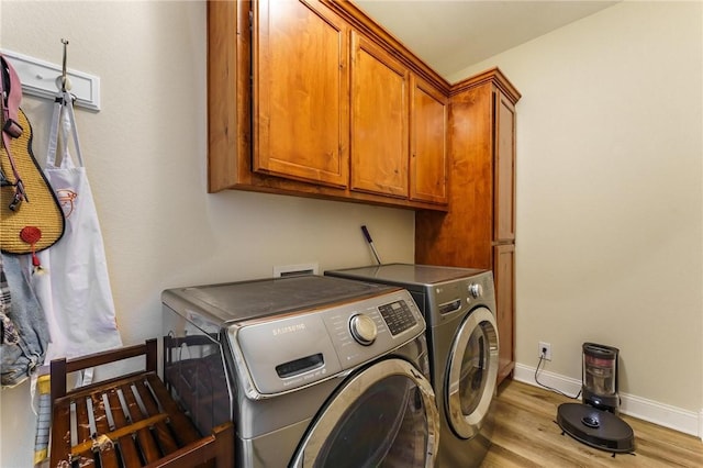 9696 Fuller Rd, Rogers, AR 72756 - laundry area featuring washing machine and dryer, cabinet space, light wood-type flooring, and baseboards
