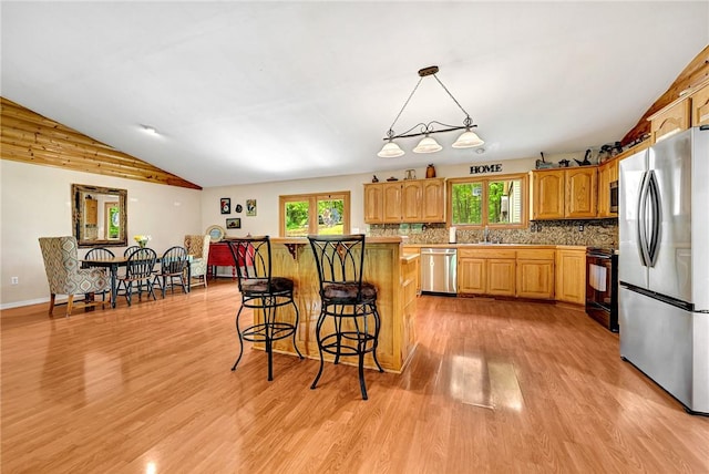 17155 Deer Park Ln, Pea Ridge, AR 72751 - kitchen with appliances with stainless steel finishes, light wood finished floors, plenty of natural light, a kitchen bar, and lofted ceiling