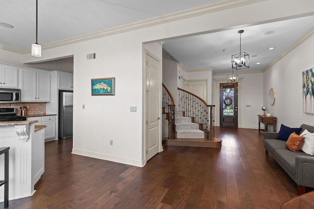 2636 Everest Ave, Rogers, AR 72758 - kitchen with stainless steel appliances, dark wood-type flooring, decorative backsplash, crown molding, and white cabinetry
