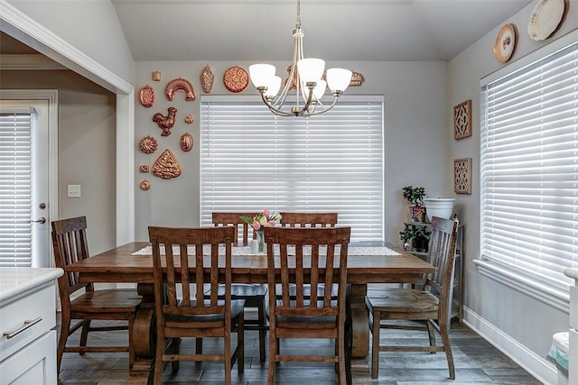 dining area featuring baseboards, a chandelier, plenty of natural light, and lofted ceiling