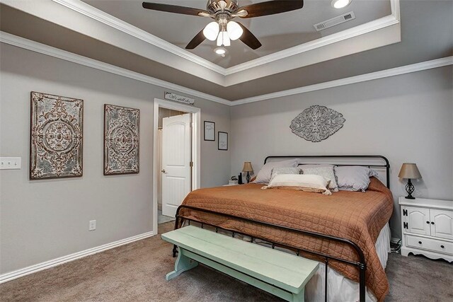 bedroom with carpet floors, a tray ceiling, crown molding, ceiling fan, and baseboards