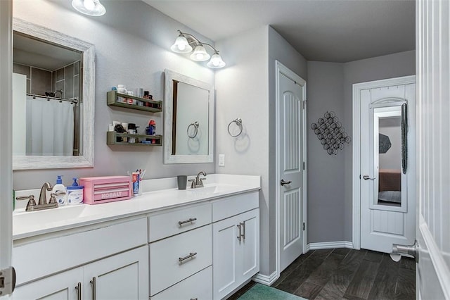 full bathroom featuring double vanity and baseboards