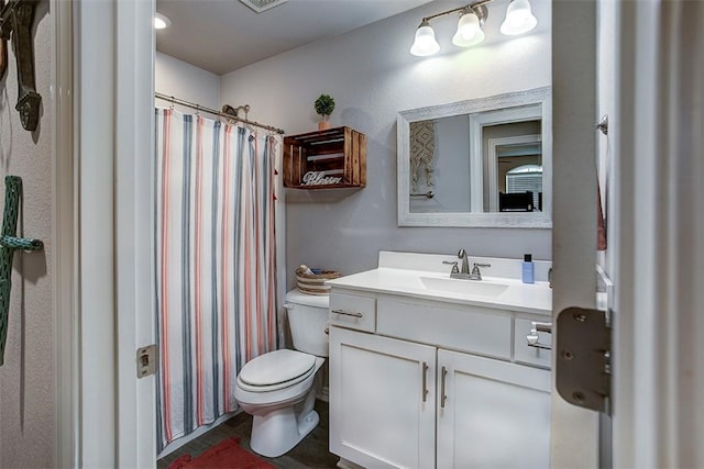 bathroom featuring toilet, vanity, and a shower with shower curtain