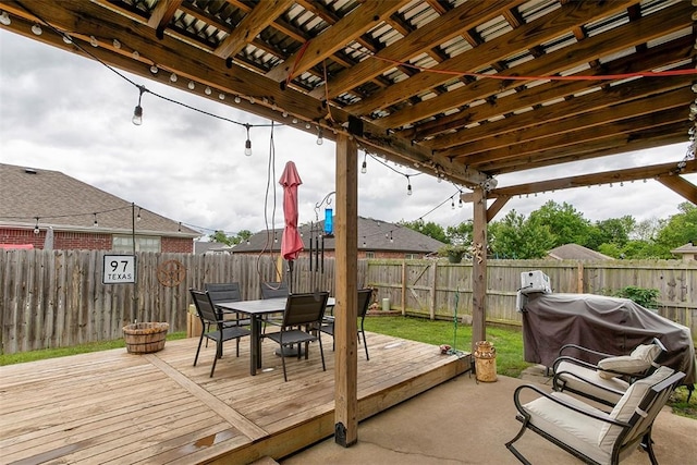 wooden terrace with outdoor dining space, a fenced backyard, and a grill