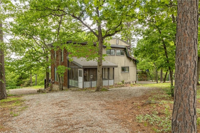 13 Rancho Vista Ln, Holiday Island, AR 72631 - view of front of property with a sunroom, dirt driveway, and roof with shingles