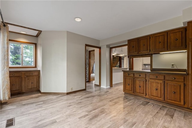 13 Rancho Vista Ln, Holiday Island, AR 72631 - kitchen with brown cabinets, light wood-style floors, and baseboards