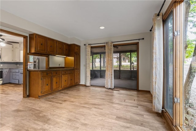 13 Rancho Vista Ln, Holiday Island, AR 72631 - kitchen featuring stainless steel fridge, brown cabinets, a ceiling fan, tasteful backsplash, and light wood finished floors