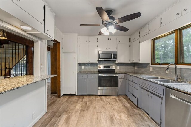 13 Rancho Vista Ln, Holiday Island, AR 72631 - kitchen featuring appliances with stainless steel finishes, a sink, ceiling fan, tasteful backsplash, and light wood-type flooring