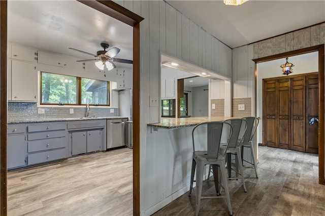 13 Rancho Vista Ln, Holiday Island, AR 72631 - kitchen featuring stainless steel dishwasher, backsplash, light wood-style flooring, and a ceiling fan