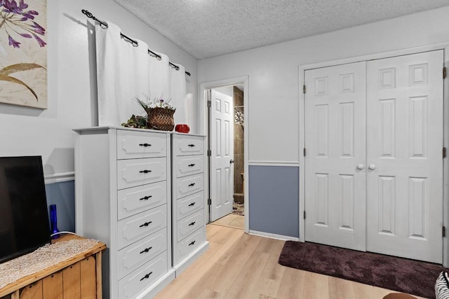 1503 Bugscuffle, Lavaca, AR 72941 - bedroom featuring light wood-type flooring, a textured ceiling, a closet, and connected bathroom