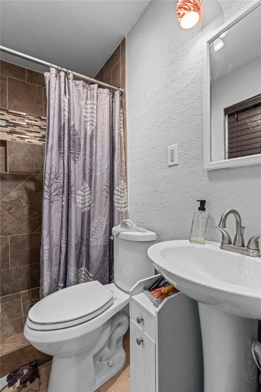1503 Bugscuffle, Lavaca, AR 72941 - bathroom featuring toilet, a tile shower, and a textured wall