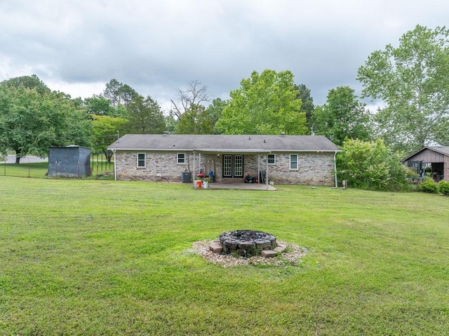 1503 Bugscuffle, Lavaca, AR 72941 - rear view of property with an outdoor fire pit, a patio, a lawn, and a storage unit