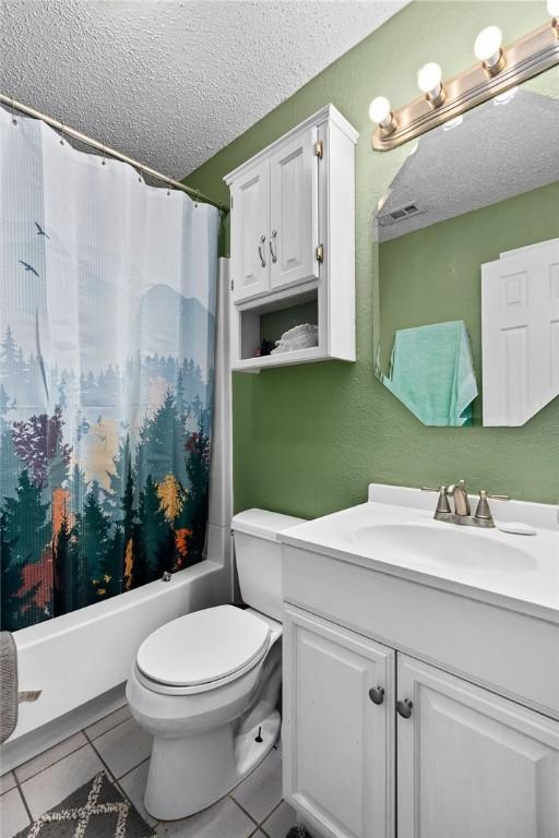 1503 Bugscuffle, Lavaca, AR 72941 - bathroom featuring a textured ceiling, vanity, tile patterned flooring, shower / bath combo with shower curtain, and toilet