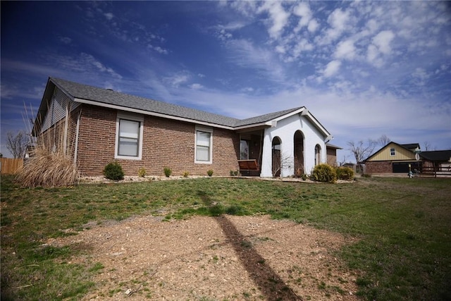 ranch-style home featuring a front lawn and brick siding