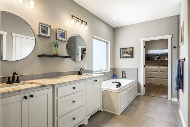 914 King Arthur Dr, Elm Springs, AR 72762 - full bath featuring tile patterned flooring, a garden tub, double vanity, a walk in closet, and baseboards