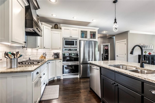 914 King Arthur Dr, Elm Springs, AR 72762 - kitchen featuring appliances with stainless steel finishes, premium range hood, a sink, white cabinetry, and backsplash