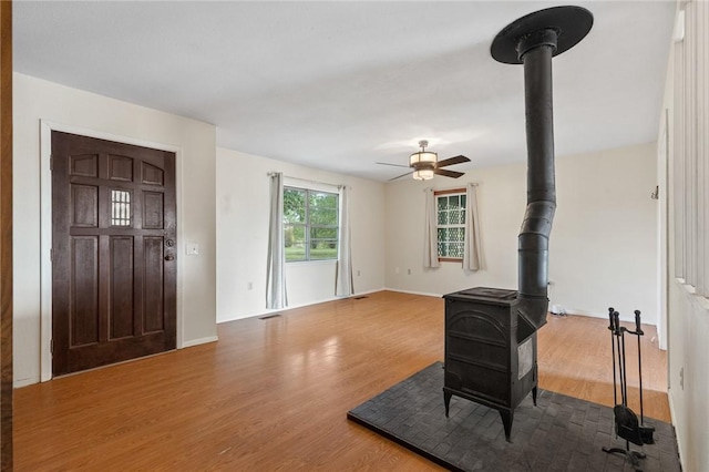 170 NC-8376, Jasper, AR 72641 - unfurnished living room with a wood stove, a ceiling fan, wood finished floors, and baseboards