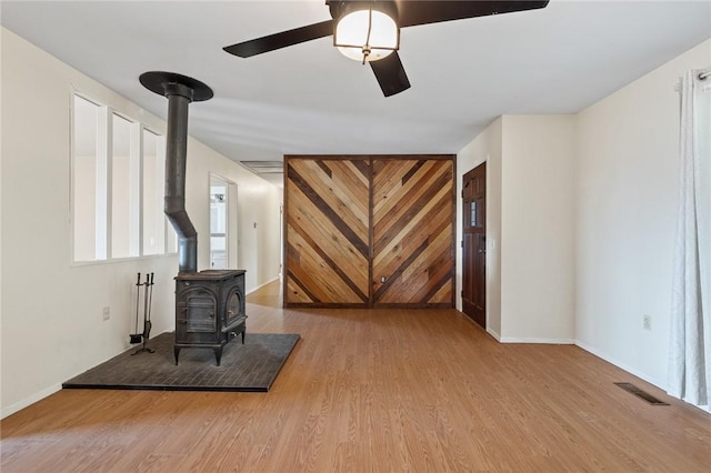 170 NC-8376, Jasper, AR 72641 - living area with a wood stove, wood finished floors, a ceiling fan, and baseboards