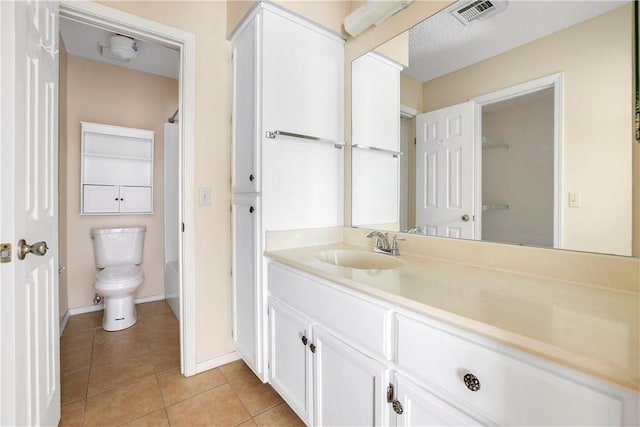 full bath featuring tile patterned flooring, vanity, toilet, baseboards, and a shower