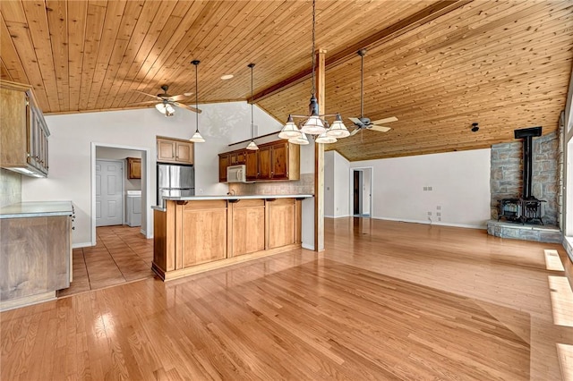 20916 Slate Gap Rd, Garfield, AR 72732 - kitchen with ceiling fan, freestanding refrigerator, a wood stove, open floor plan, and wood ceiling