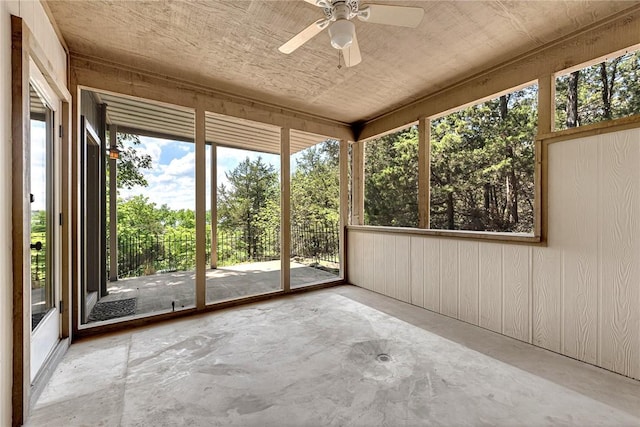 20916 Slate Gap Rd, Garfield, AR 72732 - unfurnished sunroom with a ceiling fan, concrete floors, plenty of natural light, and wooden walls